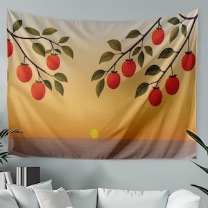 May include: A wall tapestry depicting a sunset scene with branches of red fruit and green leaves. The artwork uses a warm colour palette of orange, yellow, and brown, creating a serene and natural aesthetic. The tapestry is hanging above a white sofa.