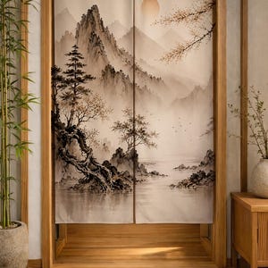 May include: A rectangular fabric door curtain featuring a printed ink-wash style landscape painting. The design depicts misty mountains, a large sun, gnarled trees, and rocky shorelines in shades of beige, brown, and black, split into two panels.