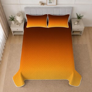 May include: A bedding set featuring a quilt and two matching pillow shams with a gradient color pattern transitioning from deep dark brown at the top to a bright golden yellow at the bottom, finished with a white piped edge trim.