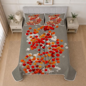 May include: A gray bedspread and two matching pillow shams featuring a pattern of thin black branches with vibrant red and orange circular leaves. The bedding set has a white piped edge and is displayed on a bed with a gray tufted headboard.