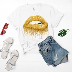 May include: White t-shirt with a gold glitter lip print. The shirt is paired with blue denim shorts.