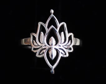 Puede incluir: Un anillo de plata con un delicado diseño de flor de loto. El anillo está hecho de una sola pieza de metal y tiene un acabado liso y pulido.