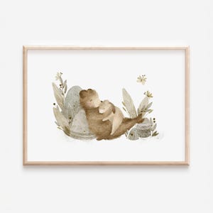 Könnte beinhalten: Aquarellillustration eines braunen Bären, der ein kleineres, helles Tier umarmt, möglicherweise ein Kaninchen. Das Kunstwerk verwendet weiche, gedämpfte Farben und ist von stilisierten Pflanzen und Blumen umgeben, in einem Holzrahmen.