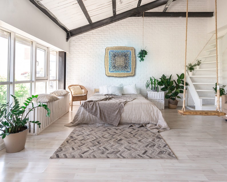 Pu&ograve; includere: Una camera da letto luminosa e ariosa con una grande finestra, un letto e un tappeto decorativo. Un quadro quadrato e ornato con dettagli blu e oro &egrave; appeso sopra il letto. Un'altalena di legno &egrave; appesa al soffitto.