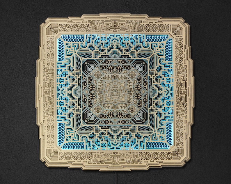 Pu&ograve; includere: Un'opera d'arte quadrata in legno a strati con intricati motivi geometrici. Il pezzo presenta una cornice marrone chiaro con un design complesso, che circonda un design centrale con strati blu e grigi. L'opera d'arte &egrave; illuminata da una luce blu tenue.