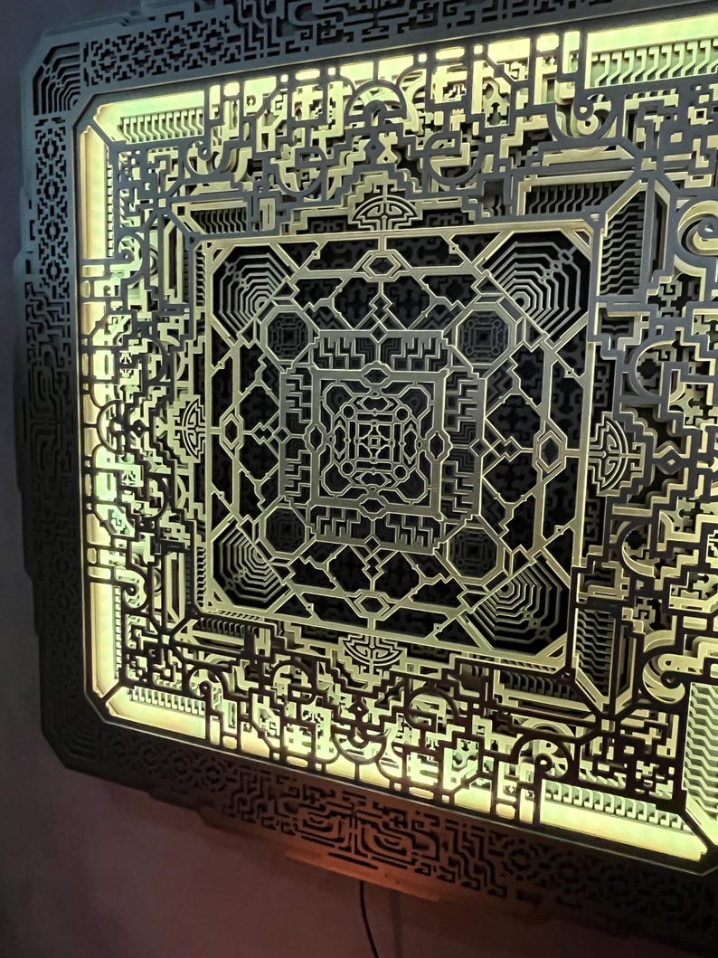 Pu&ograve; includere: Un'opera d'arte murale geometrica a strati con intricati disegni tagliati al laser. L'opera presenta un complesso motivo di forme e linee interconnesse, con un caldo bagliore giallo che emana dall'interno. L'effetto complessivo &egrave; un design astratto moderno.