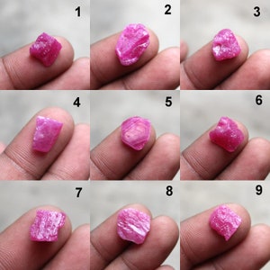 May include: Nine rough-cut, vibrant pink ruby gemstones. Each stone displays a unique shape and texture, ranging from angular to rounded. The gemstones are held up, showcasing their natural, unpolished surfaces. Ideal for jewelry making or collecting.