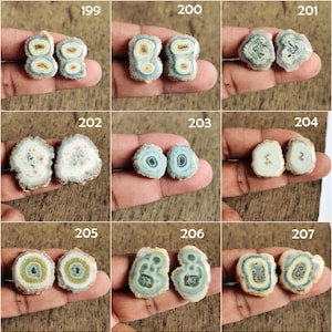 May include: Nine pairs of agate slices with different patterns and colors, including green, blue, white, and brown. The agate slices are arranged in a grid pattern on a wooden surface.