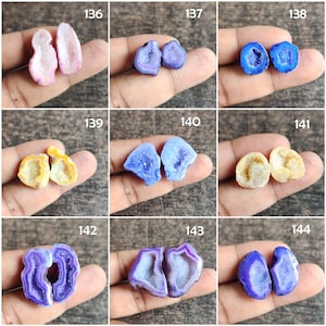 May include: A collection of nine pairs of polished, colorful geode halves. The geodes display a variety of colors, including pink, blue, yellow, and purple. Each pair is held in a hand, showcasing the unique crystal formations within.