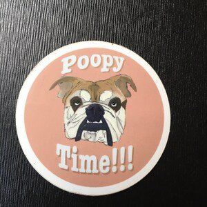Op de afbeelding: Een ronde roze en witte sticker met een cartoon bulldog en de tekst "Poopy Time!!!"