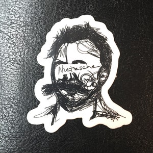 Könnte beinhalten: Schwarz-weiß-Zeichnung eines Männergesichts mit dem Wort "Nietzsche" über den Augen.