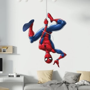 May include: A colourful illustration of Spider-Man, depicted upside down, suspended by a web. The superhero is wearing his classic red and blue suit. The artwork is detailed, showcasing the character's distinctive appearance and dynamic pose.
