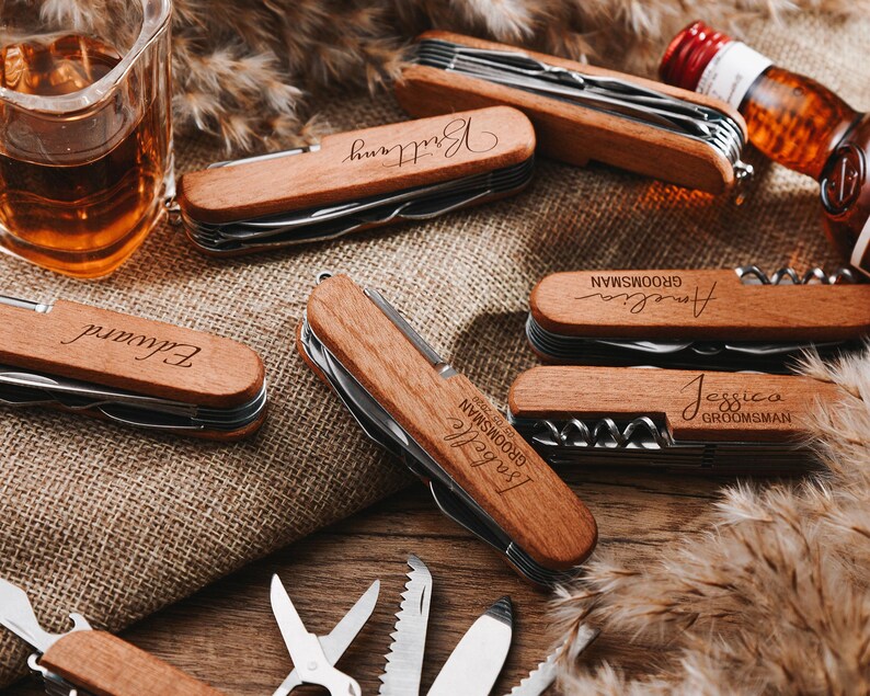 Peut inclure: Un ensemble de six couteaux de poche personnalis&eacute;s avec des manches en bois. Chaque couteau porte un nom grav&eacute; diff&eacute;rent sur le manche, notamment "Elliott", "Jessica", "Bride", "Angela", "Groom" et "Brittney".