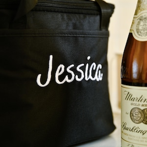 Pu&ograve; includere: Una borsa termica nera con chiusura a zip e un nome ricamato in bianco "Jessica".
