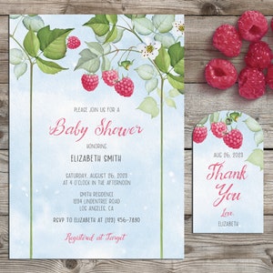 Puede incluir: Una invitación de baby shower azul y blanca con una ilustración de acuarela de ramas de frambuesas. La invitación incluye el texto "Baby Shower" y los detalles del evento, incluida la fecha, la hora, la ubicación y la información de RSVP. Una etiqueta de agradecimiento separada presenta una ilustración de frambuesa similar y el texto "Gracias" con la fecha y "Con cariño, Elizabeth".