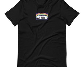 SHE/THEY Name-tag T-Shirt (50% of proceeds donated to Trans Lifeline)
