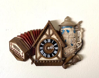 WORKING- Large Vintage quartz Wall Clock. A true homage to Germany! Cuckoo clock, pipe, stein and accordion design. Runs great- very quiet!