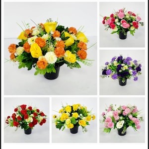 May include: Assortment of artificial flower arrangements in black pots. The arrangements feature various colours, including yellow, orange, red, pink, purple, and white.