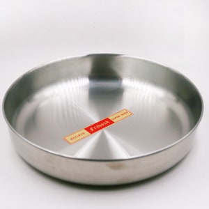 May include: A silver stainless steel cooking pan with a label that reads "Fraboak Super Inox Acciaio".