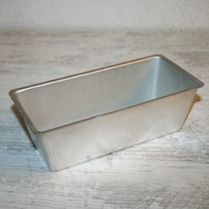 May include: A silver loaf tin, also known as a bread tin, is a kitchen baking tool used for baking bread, cakes, and other baked goods.