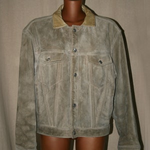May include: A brown suede jacket with a tan corduroy collar and button closure. The jacket has two flap pockets on the chest and two angled pockets at the waist.