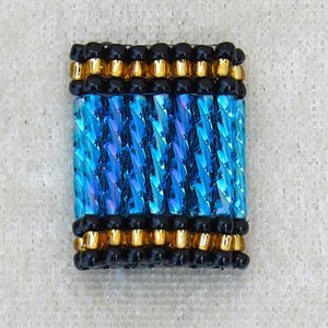 May include: A rectangular beaded component featuring a central section of vertical, iridescent blue twisted glass tube beads. This section is bordered on the top and bottom by horizontal rows of black round beads and metallic gold cylindrical beads.