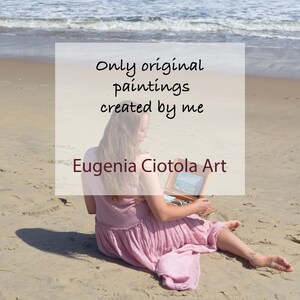 May include: A person in a light pink dress sitting on a sandy beach holding a small wooden painting box. The text overlay reads: Only original paintings created by me. Eugenia Ciotola Art. The ocean waves are visible in the background.