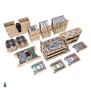 May include: A collection of laser-cut wooden game organizers and card holders. The set includes various containers for cards, tokens, and game pieces, with a light brown finish. Some containers hold gray miniature figures.