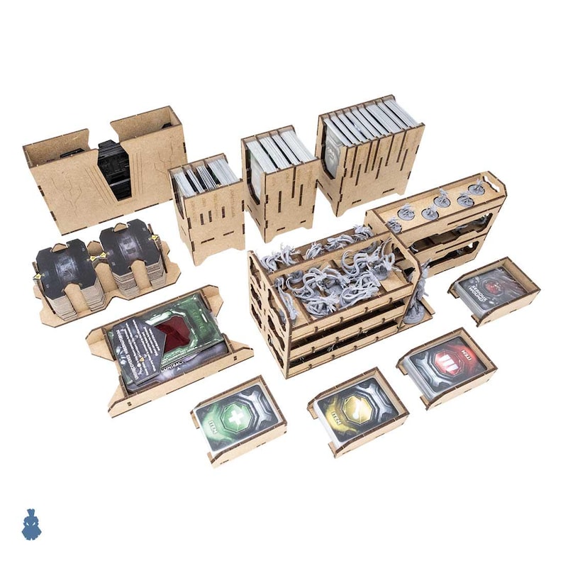 May include: A collection of laser-cut wooden game organizers and card holders. The set includes various containers for cards, tokens, and game pieces, with a light brown finish. Some containers hold gray miniature figures.