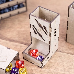 May include: A wooden dice tower with a cut-out design, holding red and purple dice. Other wooden boxes and dice are also visible, suggesting a tabletop gaming theme.