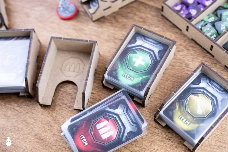 May include: Wooden card holders with stacks of game cards featuring health, ammo, and other item icons. The cards are labeled "ITEM" and are in various colors. Other wooden game pieces are also visible.