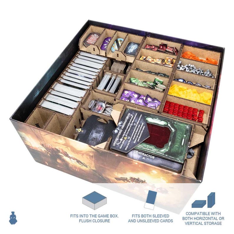 May include: A wooden game organizer with multiple compartments filled with game pieces, cards, and tokens. The organizer is designed to fit inside a game box and accommodate both sleeved and unsleeved cards. The text on the card reads "CONTRACTOR".