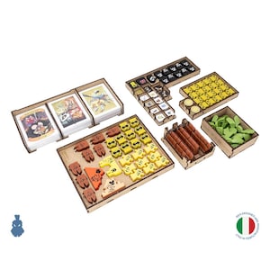 Puede incluir: Un conjunto organizador de madera para juegos de mesa que contiene varias bandejas llenas de componentes. El set incluye tarjeteros, fichas cuadradas pequeñas con iconos, piezas amarillas con forma de ratón, bloques marrones y fichas verdes.