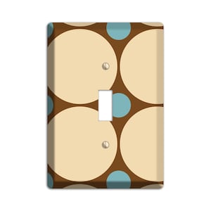 May include: A light switch cover with a brown background and a pattern of overlapping beige and blue circles.
