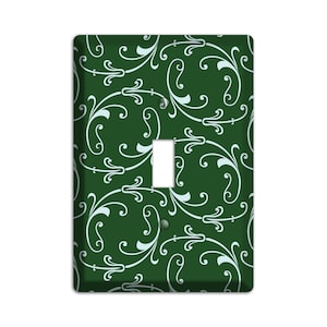 May include: A green light switch cover with a white, swirling, floral pattern.
