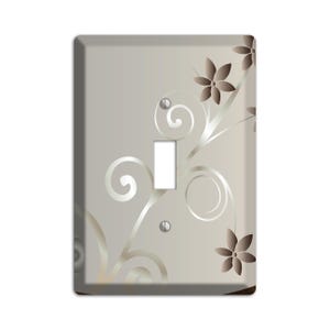 May include: A light gray wall plate with a decorative floral design in silver and brown. The design features swirling vines and flowers.