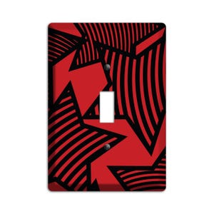 May include: A red and black geometric pattern light switch cover with a black light switch in the center.
