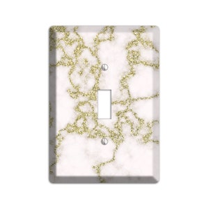 May include: White light switch cover with a gold glitter marble pattern.