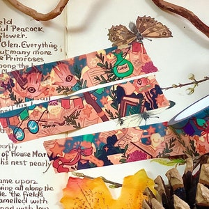 May include: Assortment of colorful washi tapes featuring whimsical illustrations of owls, books, glasses, and stars. The tapes are rolled up and displayed on a book with autumn leaves and a pine cone.