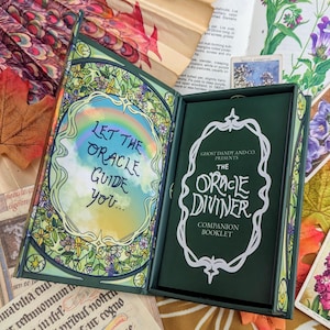May include: A green and white oracle card deck box with the text "Let the Oracle Guide You..." on the front and "The Oracle Diviner Companion Booklet" on the back.