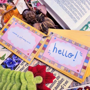 May include: A yellow and pink card with a cloud and the text "creased by guard dandy are co" and another yellow and pink card with a cloud and the text "hello!"