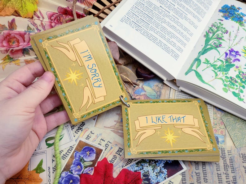 May include: A set of small cards with gold backgrounds and green borders. The cards have a star and a banner with the text "I'M SORRY" and "I LIKE THAT" on them.