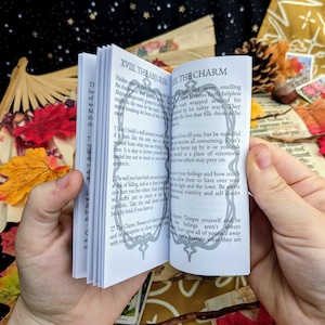 May include: Open book with black and white illustrations and text. The text reads "XVIII. The Abiure" and "The Charm". The book is open to a page with text about love and how to be mindful of your feelings.