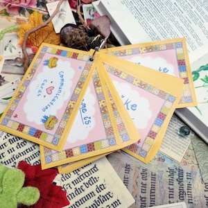 May include: A set of pink and yellow communication cards with a patchwork design. The cards feature a frog and the text "Communication Cards" and "me is:"