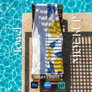 May include: A white beach towel with a lemon and leaf design in yellow and blue is draped over a wooden lounge chair. The towel is placed near a pool with clear blue water. The word "Towel" is printed on the left side of the image.