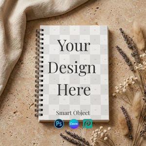 Może przedstawiać: Spiralny notatnik z tekstem "Your Design Here" pogrubioną, czarną czcionką. Notatnik ma wzór kratki na okładce i słowa "Smart Object" pod tekstem. Obraz zawiera również logo Photoshopa, Canvy i trzeciej platformy projektowej.