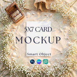 May include: A white 5x7 card mockup with the text 5X7 CARD MOCKUP Smart Object, surrounded by white baby's breath flowers, seashells, a wooden ring box containing two gold rings, and three software icons on a sandy textured background.