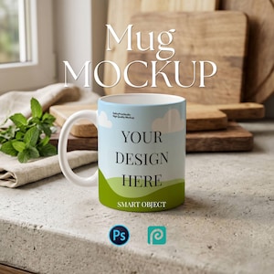 以下が含まれることがあります： 白いセラミックマグカップ、ハンドル付き、空と草のデザインで「YOUR DESIGN HERE」と「SMART OBJECT」の文字入り。 マグカップは、木製のまな板のあるニュートラルな背景に置かれています。