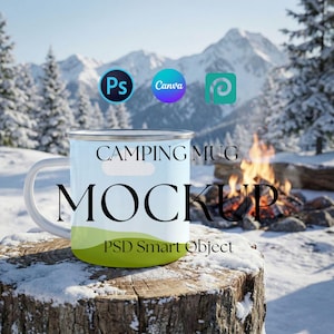 Könnte beinhalten: Hellblaue Campingbecher-Mockup mit den Worten "CAMPING MUG MOCKUP" in Schwarz. Der Becher hat einen weißen Griff und einen grünen Boden. Der Hintergrund zeigt eine schneebedeckte Berglandschaft und ein Lagerfeuer.