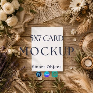May include: A white 5x7 card mockup with the text 5X7 CARD MOCKUP and Smart Object printed in dark blue. The card is surrounded by white roses, dried pampas grass, a white lace fabric, and a small candle on a rustic wooden surface.